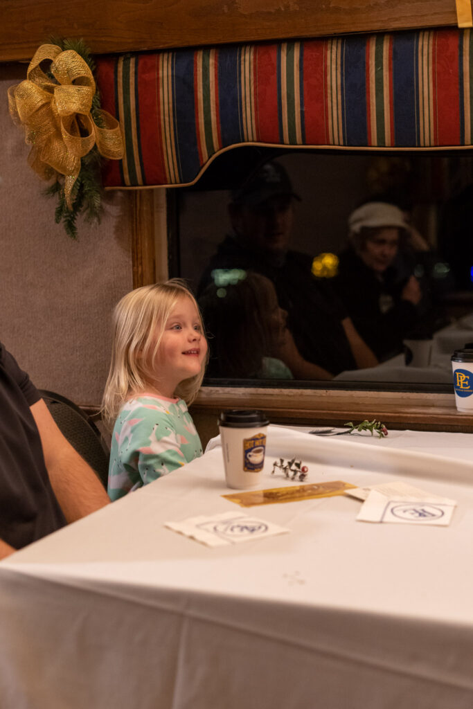 A little girl smiling aboard the Polar Express Christmas train ride in Branson, Missouri
