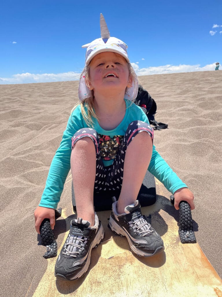 Girl Sand Sledding, one of the best things to do at Great Sand Dunes National Park in Colorado