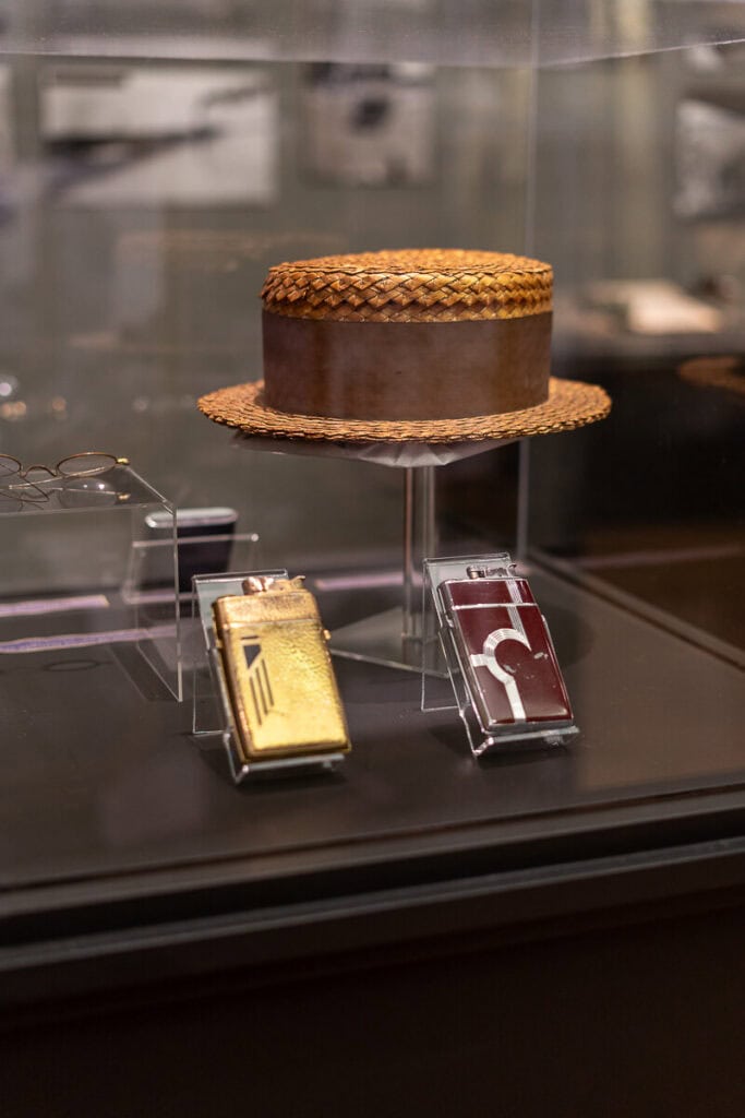 Tulsa Historical Society & Museum 1920s exhibit with old lighters, hat, and glasses.
